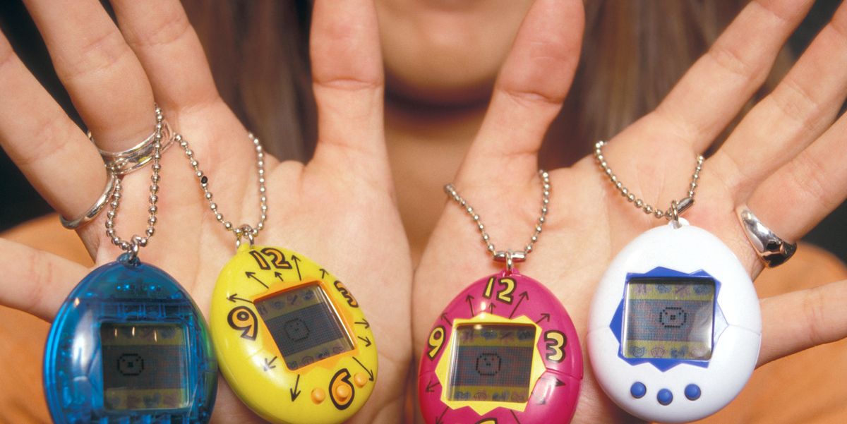 person holding four tamagotchis on hands