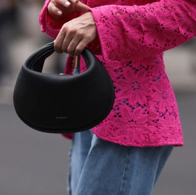 a woman at new york fashion week carries a black bag with a pink shirt to illustrate a guide to the best gifts under $100