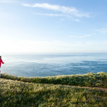 a person running on a path by the water