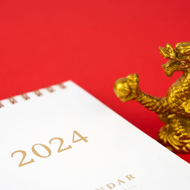 year of the dragon 2024 calendar and golden dragon toy on red background