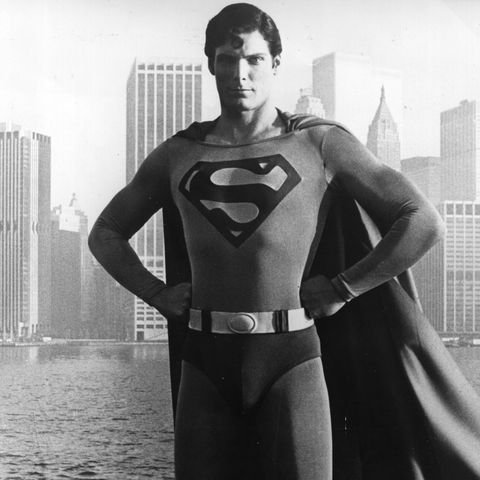christopher reeve stands before the manhattan skyline dressed as the comicbook hero of the film 'superman'