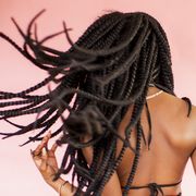 young black woman with hair in braids from behind, flipping hair