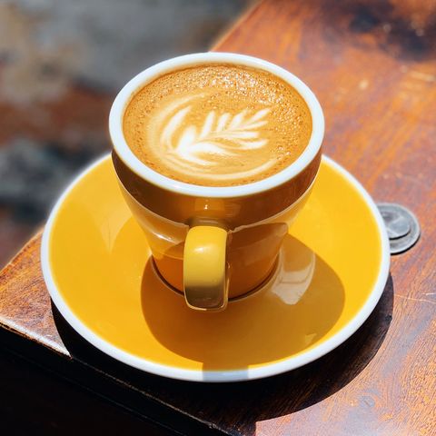 yellow coffee cup with cappiccino