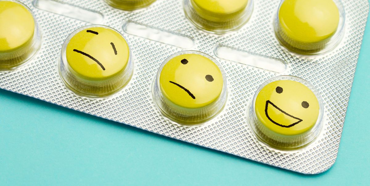Yellow pills andfunny faces in a blister on a blue background.