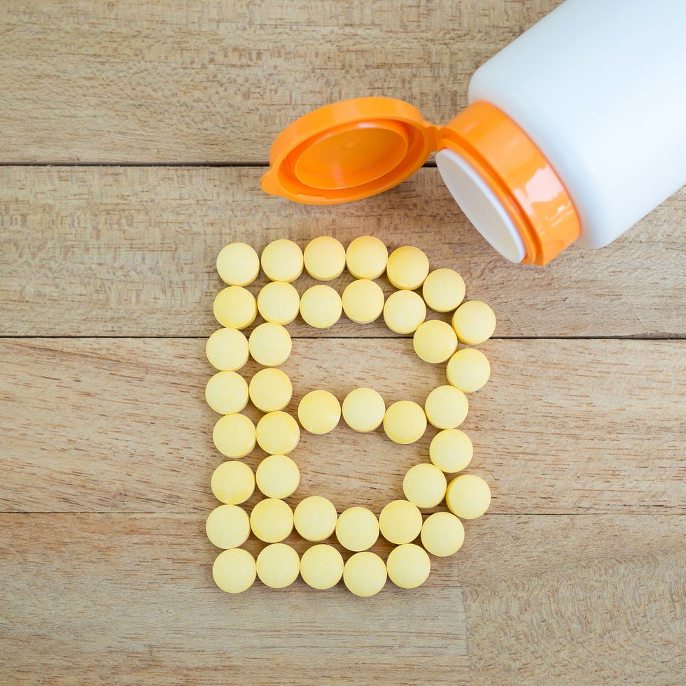 yellow pills forming shape to b alphabet on wood background