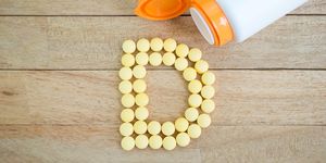 yellow pills forming shape to d alphabet on wood background ビタミンd　メリット　摂取　日光　健康　ヘルスケア