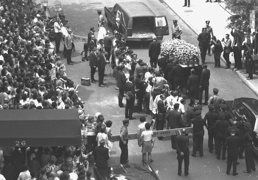 yellow roses cover judy garland's coffin as it is taken to h