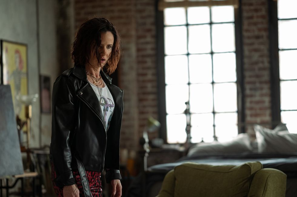 juliette lewis wears a leather jacket and stands in a studio looking surprised in a scene from yellowjackets