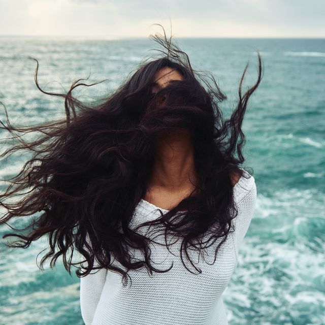 vrouw op strand met haar in de wind