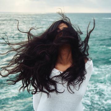 vrouw op strand met haar in de wind