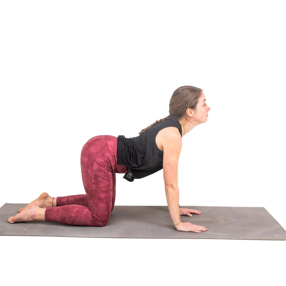 a woman doing a yoga post against a white background