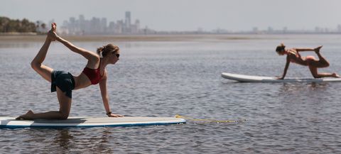 4th of july activities woman doing paddle board yoga on a beach