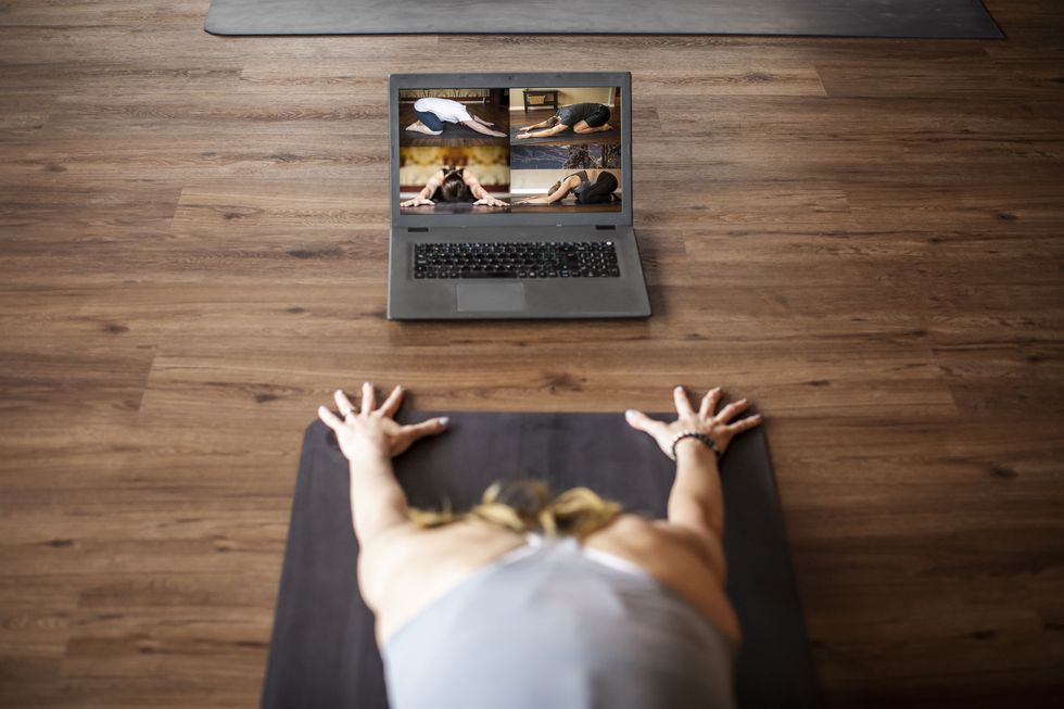 yoga instructor teaching online class from studio