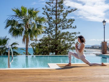 a woman in a white outfit by a pool