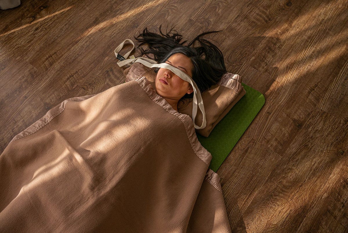 Een vrouw ligt in Sawasana in een studio in Beijing Yoga kwam in China langzaam op gang er heerste argwaan tegenover de spirituele aspecten ervan Inmiddels verspreidt het zich snel