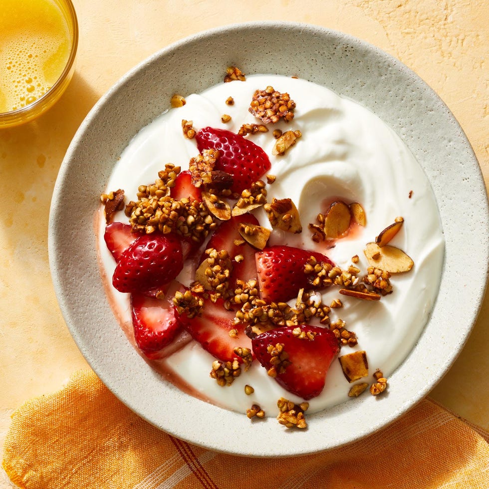a bowl with yogurt, granola and strawberries