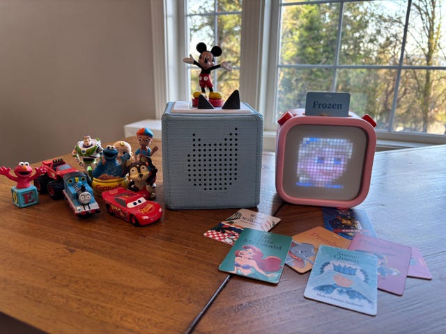 variety of childrens toys and a storytelling device on a wooden table