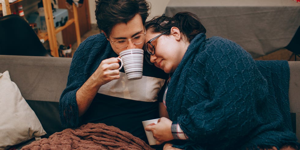 Pareja de jóvenes adultos compartiendo una noche acogedora juntos en casa con bebidas calientes pareja de jóvenes adultos compartiendo una noche acogedora juntos en casa con bebidas calientes