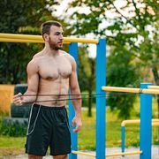 young adult man stretching outdoors before workout