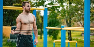 young adult man stretching outdoors before workout