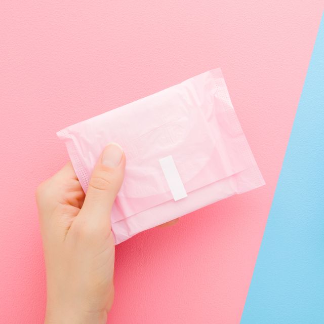 young adult woman hands holding two packs of sanitary towel on light pink blue table background pastel color closeup protection in day and night time point of view shot top down view two sides