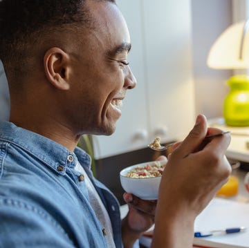 young african american man eating healthy snack at home