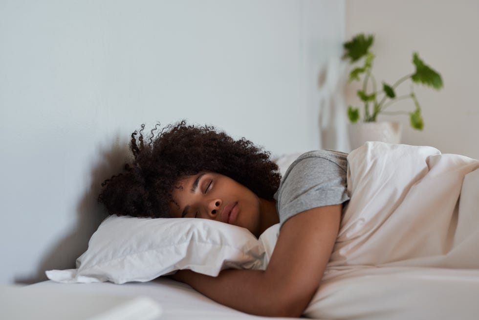 young african woman sleeping in her bed in the morning