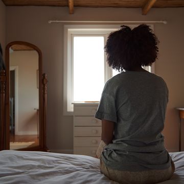 young african woman suffering from depression sitting in her bedroom