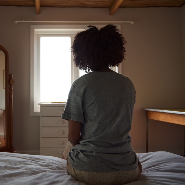 young african woman suffering from depression sitting in her bedroom