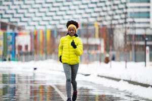 young african woman training outdoors in bad weather