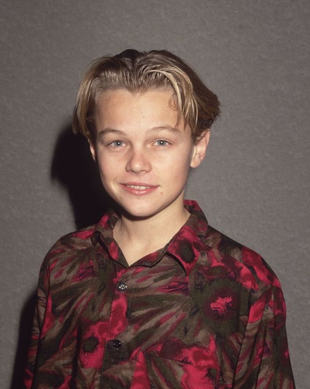 leonardo dicaprio as a child, wearing a red patterned button shirt