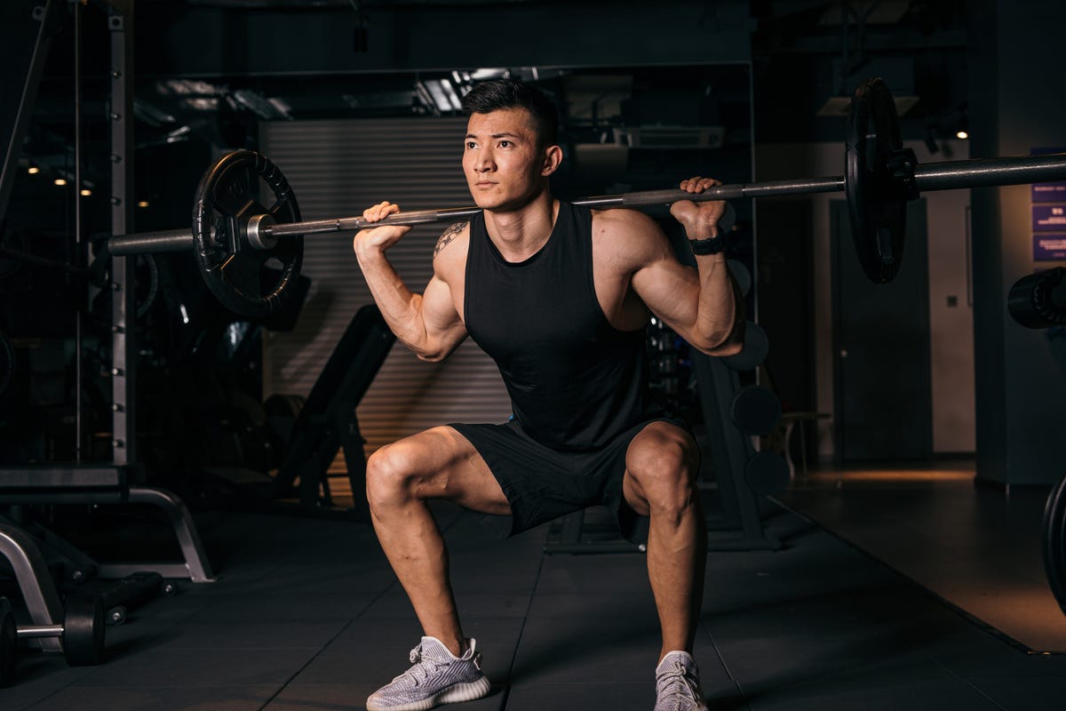 Asian woman with strong and muscular firm shape is training on leg day by  doing advance jump squat for thigh and calf muscle in the gym for healthy  and strong lower body