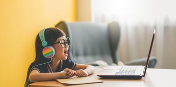 young asian cute girl studying with laptop at home during pandemic