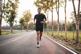 young asian male runner sprint run on the road sunset outdoors