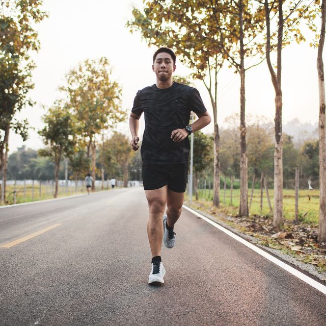 young asian male runner sprint run on the road sunset outdoors