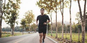 young asian male runner sprint run on the road sunset outdoors
