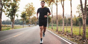 young asian male runner sprint run on the road sunset outdoors