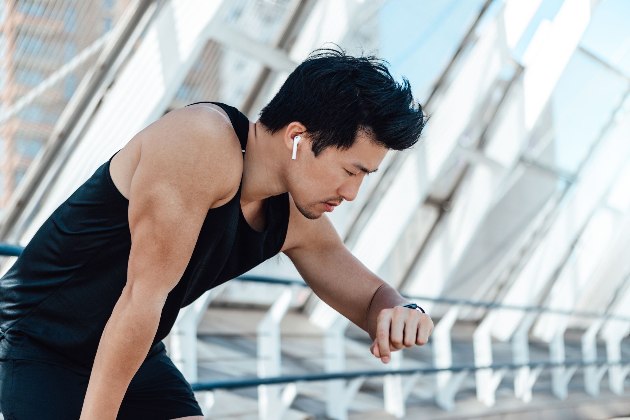 Hombre joven con auriculares haciendo ejercicio en el gimnasio.