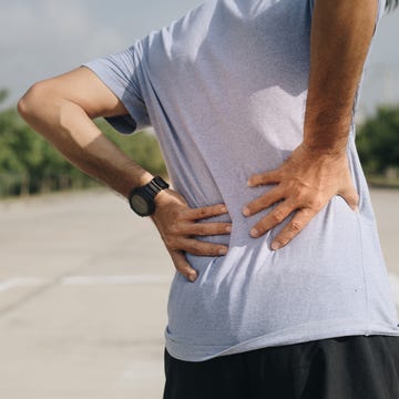 A young Asian man has pain after exercise, Sport injury, Man with back pain a young asian man has pain after exercise, sport injury, man with back pain