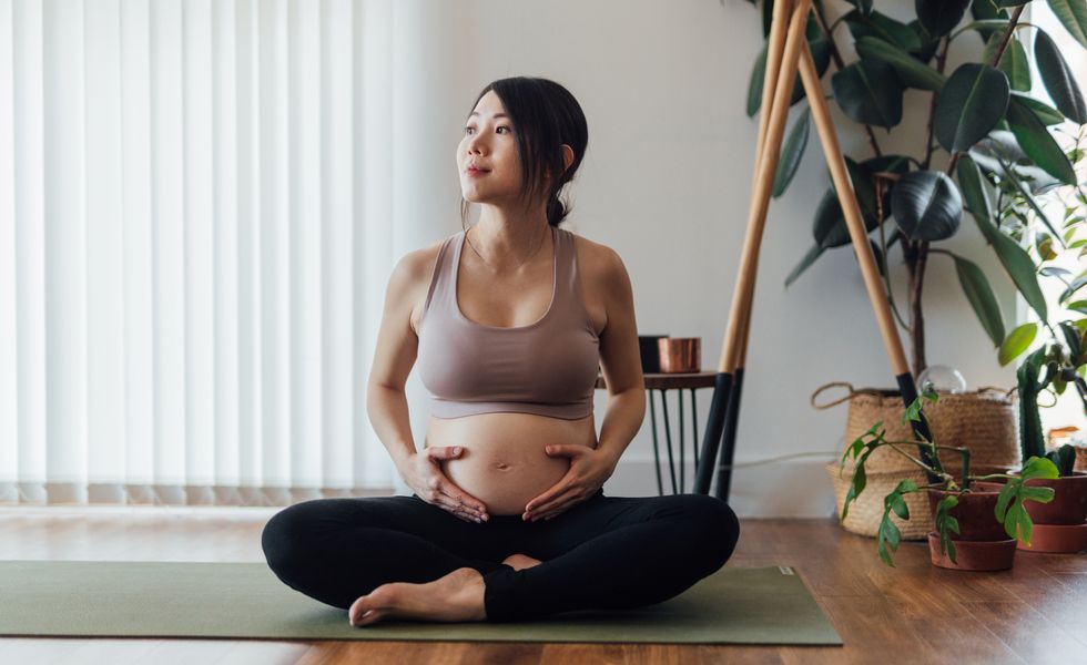 young asian pregnant woman practising yoga at home