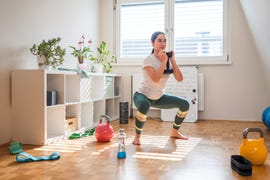 young asian woman exercising with weights at home