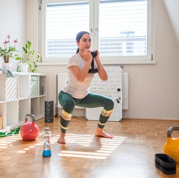 young asian woman exercising with weights at home