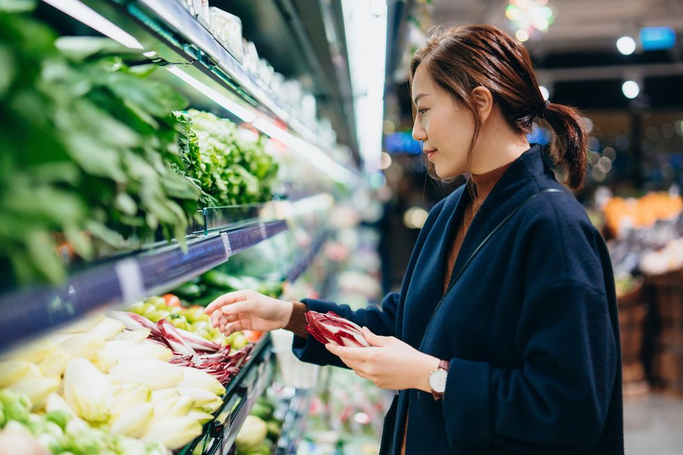 young asian woman grocery shopping in supermarket, choosing fresh organic fruits and vegetables along the produce aisle fruits and vegetables shopping routine shopping zero waste healthy eating diet and go green lifestyle