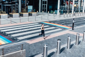 young asian woman running on zebra crossing