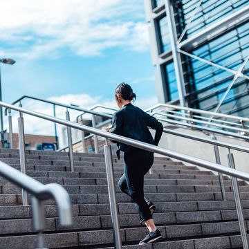 young asian woman running upstairs in finance district