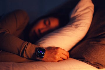 young asian woman using sleep tracker app on smartwatch to monitor her sleep cycle