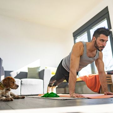 young athlete doing push ups on exercise mat in living room
