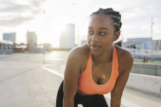 young athlete woman with sweat on her face exercising outside the city. effort and youth concept.