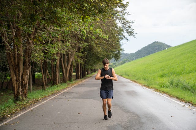 young athletic man running at park during cold autumn morning