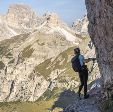 young athletic woman enjoys scenic view on tre cime , dolomites, south tirol, italy, europe